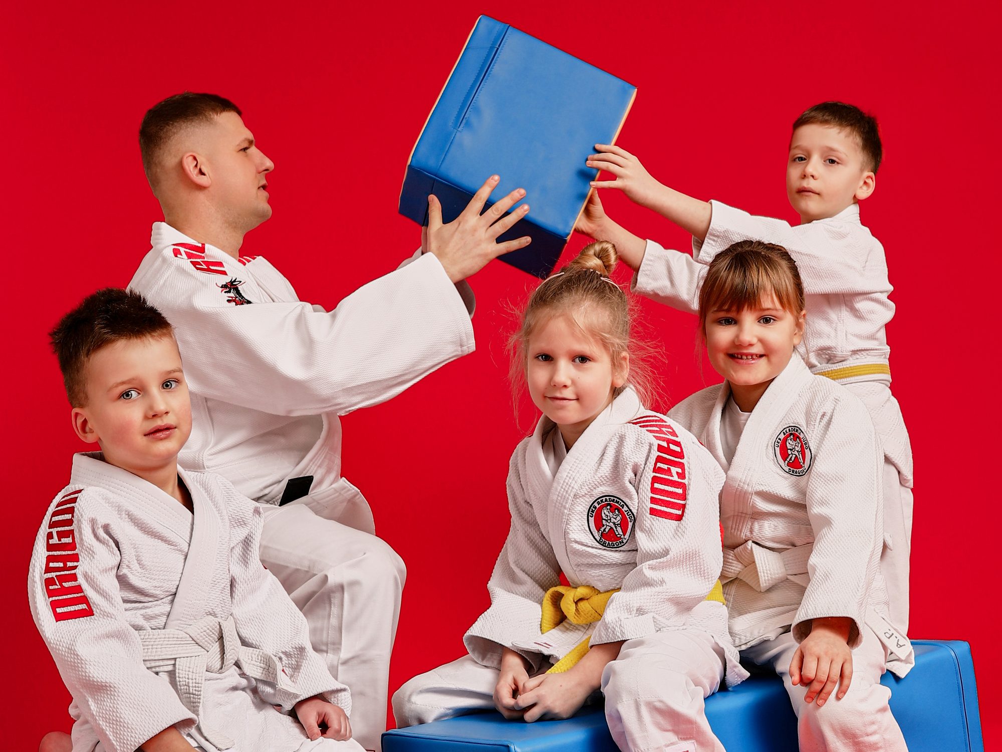 Trener Akademii Judo Dragon i czworo przedszkolaków w judogach na miękkich klockach