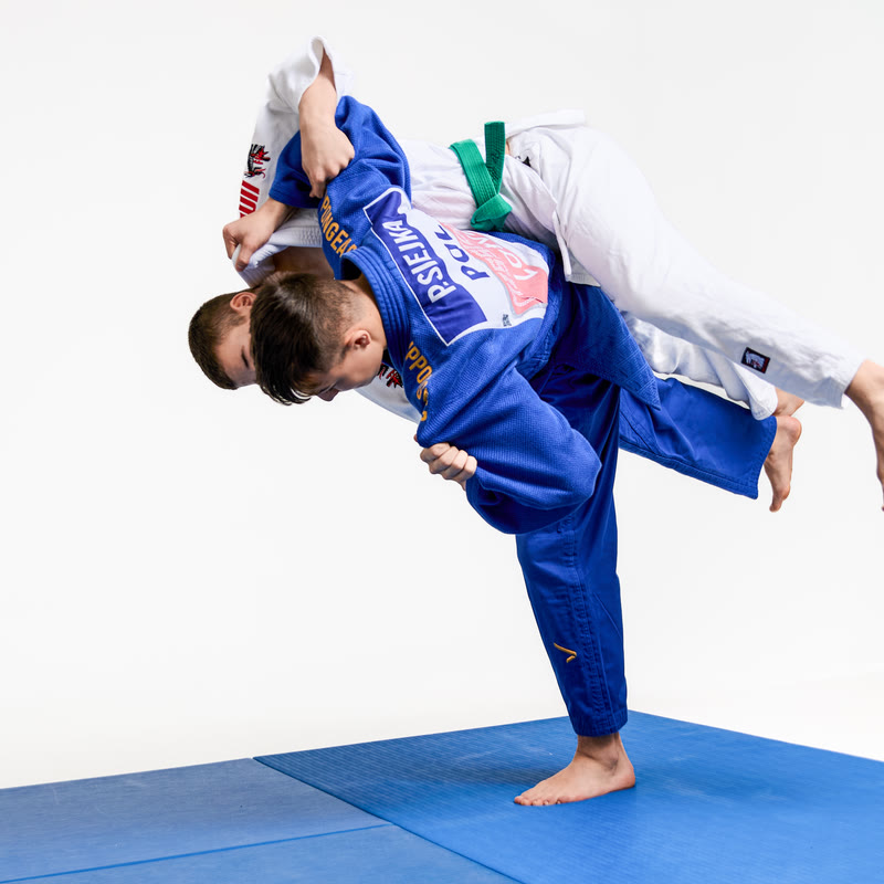Judoka wykonuje rzut na macie